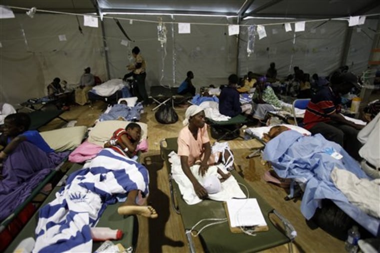 Patients rest on cots at the University of Miami-run field hospital in Haiti's international airport in Port-au-Prince on Saturday. The White House said the suspension imposed on Wednesday was being lifted because it has been assured that there is space for Haitian patients at U.S. hospitals.